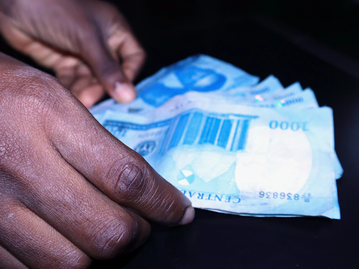 A hand fanning out ₦1,000 notes